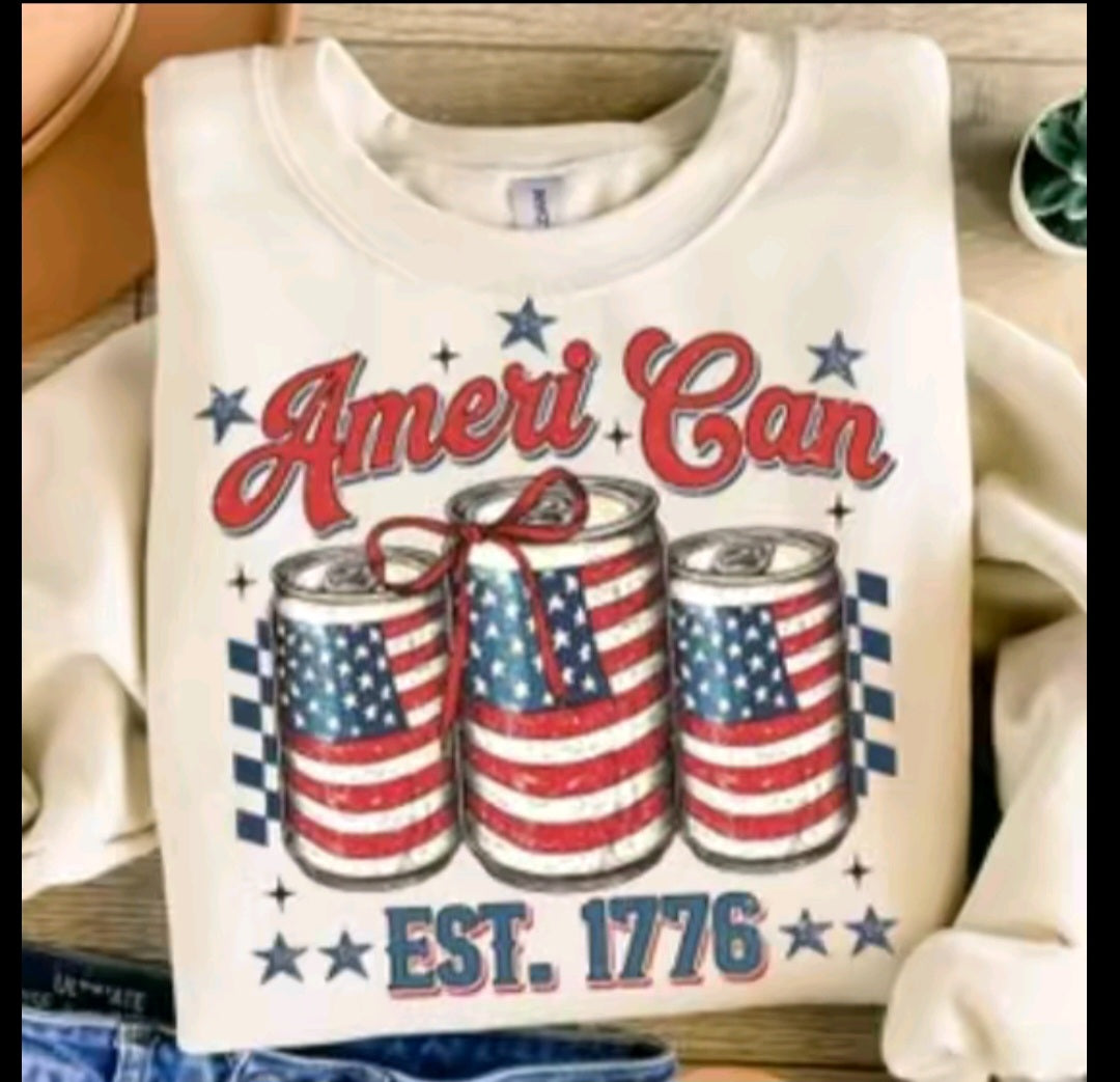 White sweatshirt with 'Ameri Can' design featuring American flag-themed cans and 'EST. 1776' text.